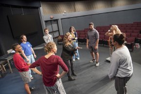 Group of theatre students on stage in a circle