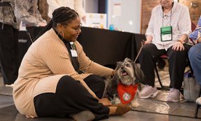 A staff member bonds with a therapy dog in Cromer Center