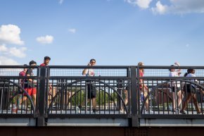 Students walk across a bridge on a sunny day