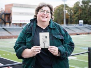 LR professor Janet Painter holding a picture of her dad and LR legend Hanley Painter in uniform during World War II.