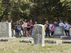 Students stand outside in a large group at Oakwood Cemetery.