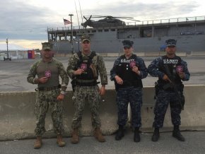 Amy Sain, third from left, stands outside with her fellow Navy men outside in front of a ship