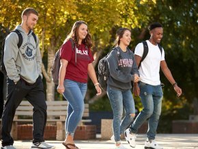 Group of students walking across campus to class