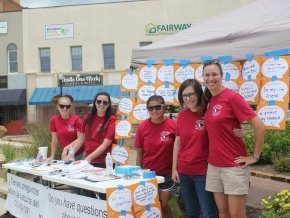 Taylor Newton, Ph.D., far right, stands with a group of student volunteers at an outdoor event.