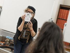 Lynda Barry holds up a drawing