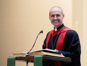 The Rev. Dr. Chad Rimmer stand at a podium