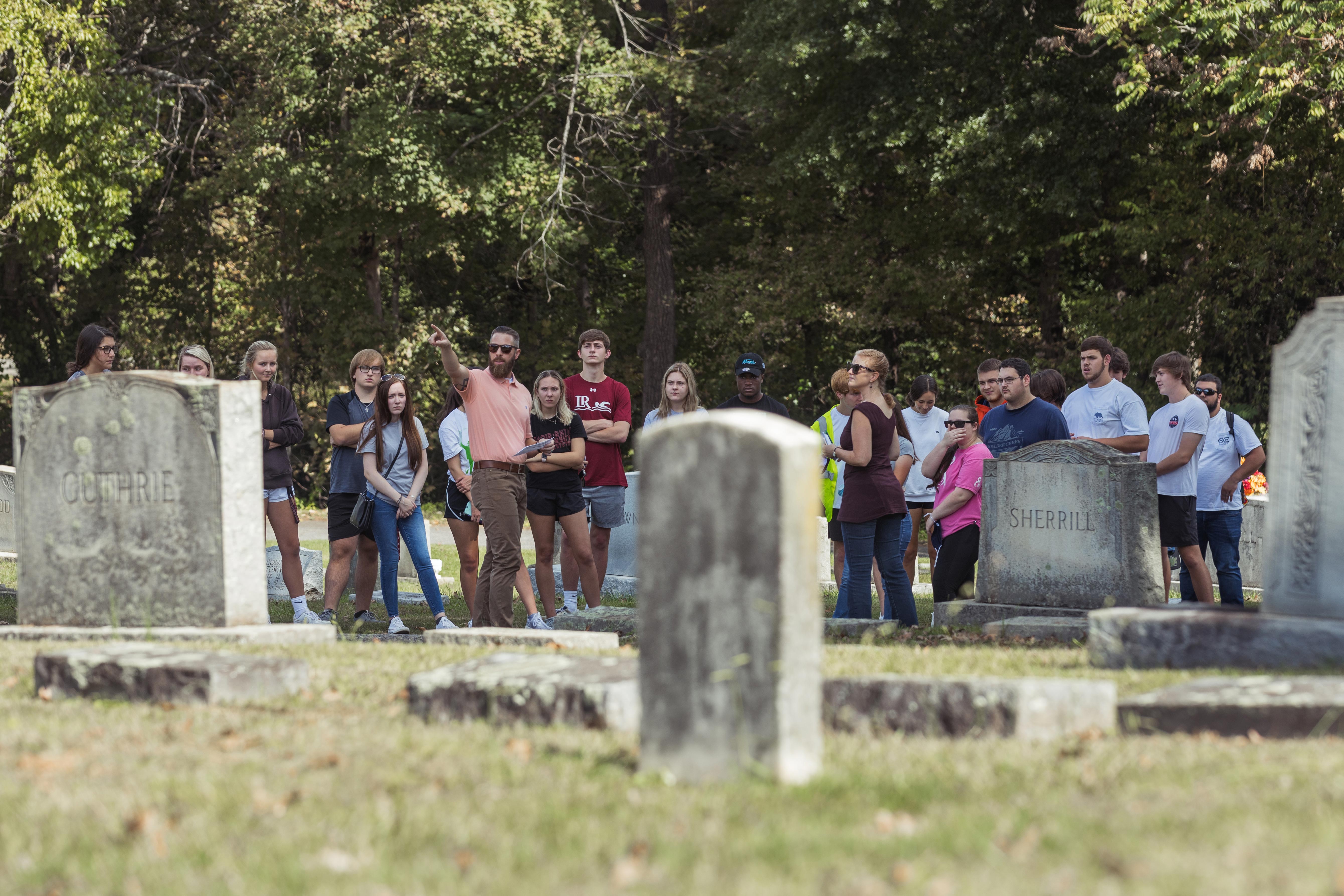 Students stand outside in a large group at Oakwood Cemetery