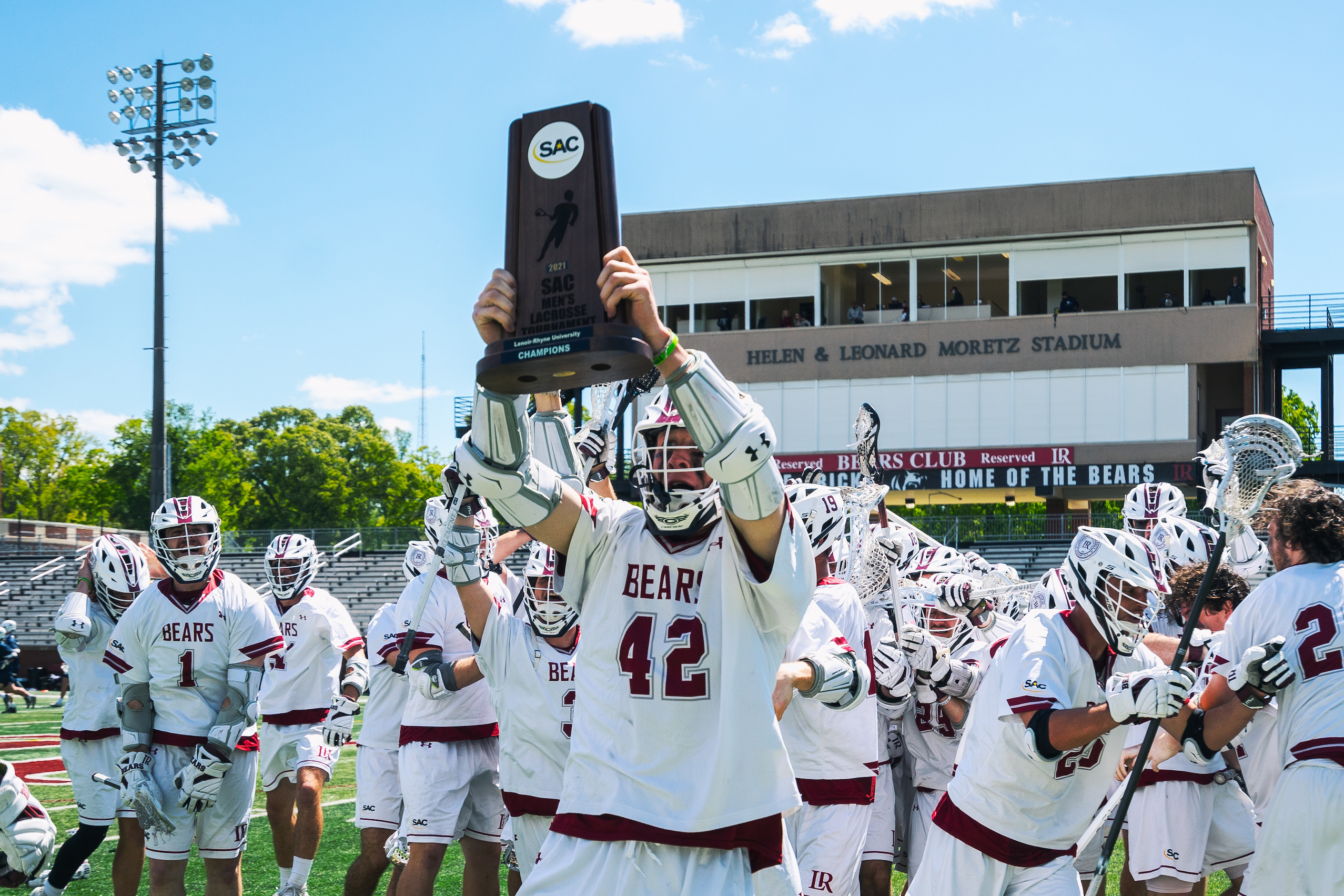 All-American and all-time scoring record holder Eric Dickinson ’21 holds up the South Atlantic Conference championship trophy.