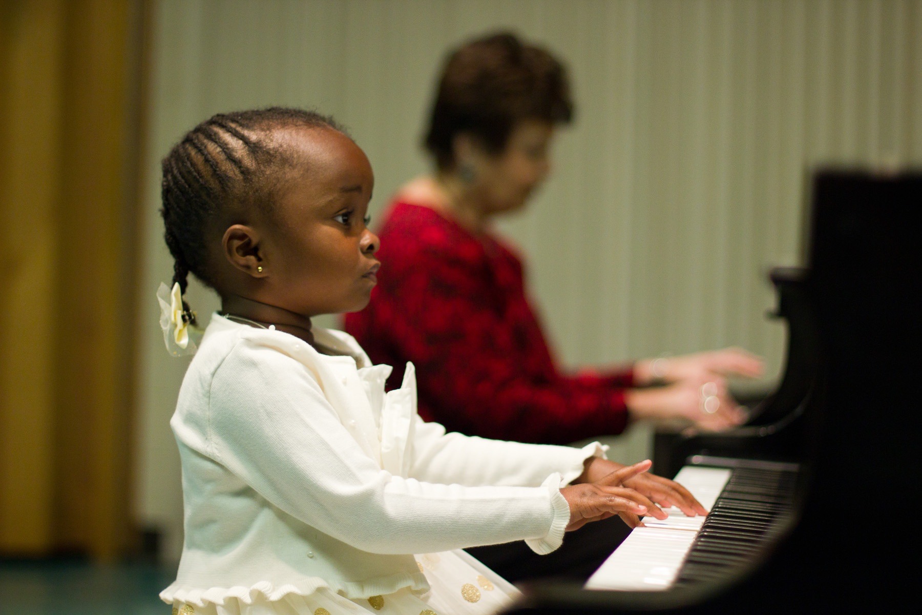 A young girl plays the piano
