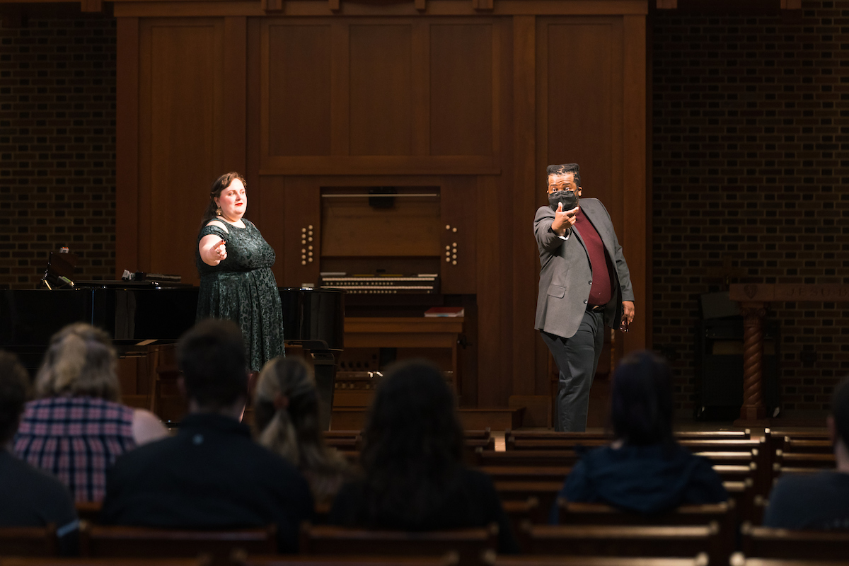 Alexandria McNeely stands on stage, left with Sidney Outlaw, right