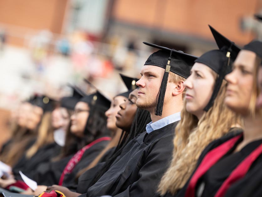 Graduates in crowd listen to speaker on stage during 2023 Hickory commencement ceremony