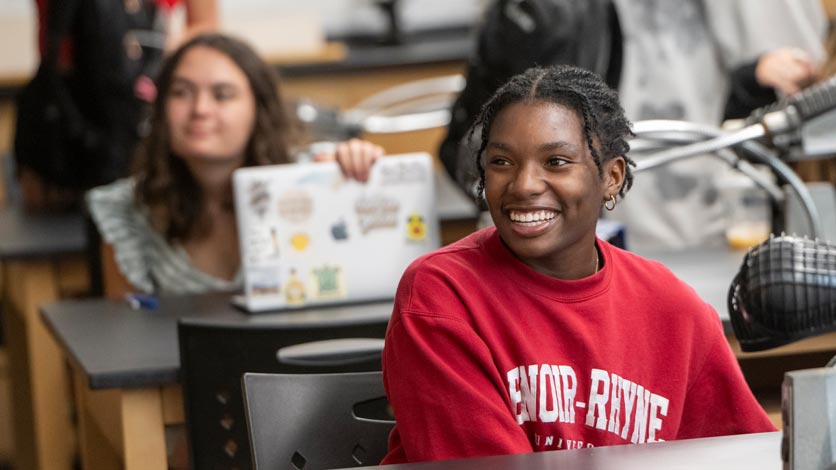 Student smiling in classroom at the start of class