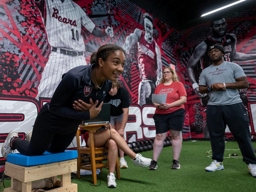 Exercise science students work on group activity in fitness center during class