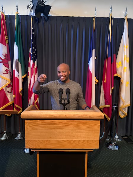 Marcus Slade standing behind a podium 