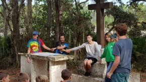 Students stand outside and hold hands while praying