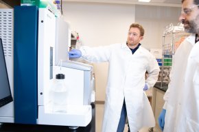 Two men look at equipment inside a lab