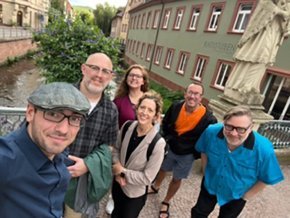 A group of people stand outside to take a selfie