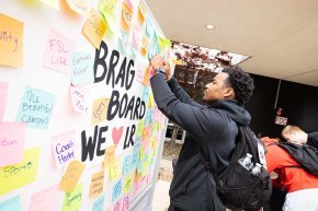A student writes on the Bears Give Back brag board