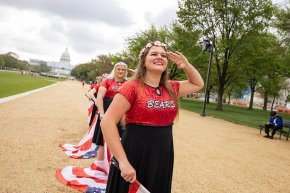 Marching band flag corps salutes at the Capitol