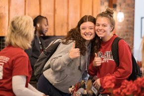 Students hug and give a thumbs up at Bears Give Back