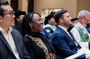 Lillian Okoronkwo sits in a church pew amongst other congregation members. 