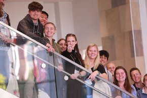 Students and faculty wave from balcony at NCAS meeting