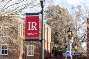 Banners on light posts along the quad by Mauney-Schaeffer during installation in late spring