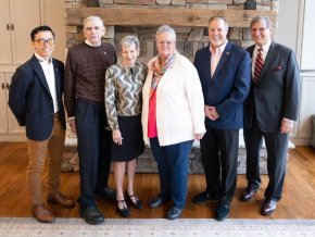Five alumni award winners and President Whitt stand in front of a stone wall.