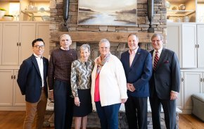 Five alumni award winners and President Whitt stand in front of a stone wall.
