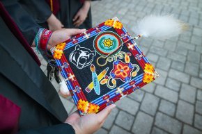 Closeup of a graduation cap decorated with beads in a variety of colorful motifs