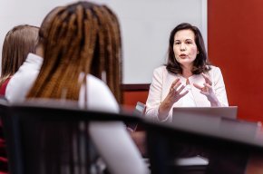 Christina Walker leads students in a discussion at a conference table