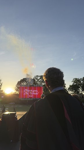 Dr Whitt in profile watching fireworks explode over the stadium display thanking him for his service