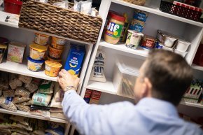 Pastor Todd Cutter places stock on a shelf in the current food pantry