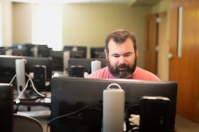 Mike Gerbitz works behind a computer screen in a campus lab