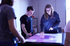 PA students gather around a light table to view scans
