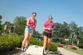 Two students play cornhole on Shaw Plaza