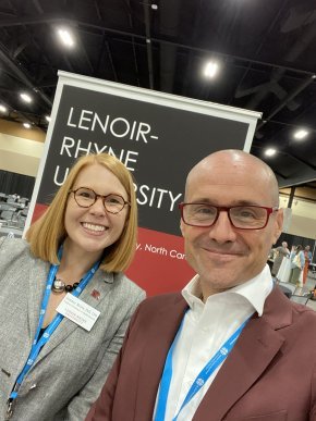 Summer McGee and Chad Rimmer stand in front of an LR banner at the ELCA Churchwide meeting
