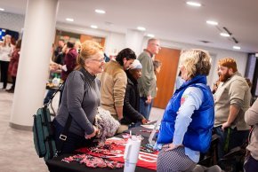 An LTSS student chats with a staff member over a table at a student services fair