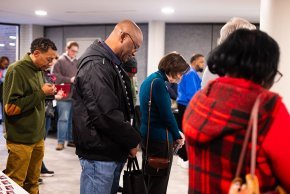 Seminary students bow their heads in prayer together in Belk Centrum 