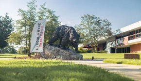 The Charge statue next to a Lenoir Rhyne Banner and Cromer Center in the background
