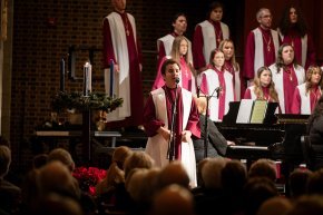 Student sings a solo with the choir in the background during a Lenoir-Rhyne Christmas 