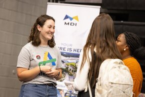 LR alumna Carly Godfrey talks to students at the Alex Lee booth at the Career Fair
