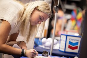 A student fills out a form at a career fair booth