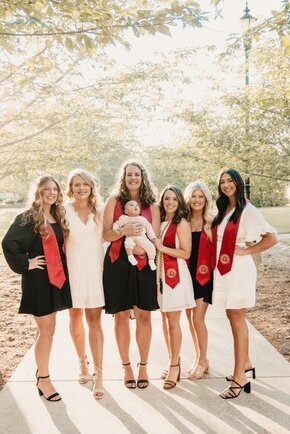 Alyssa Sack with her cohort and infant daughter Abigail in commencement regalia