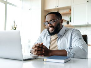 Student completing course work on computer in kitchen