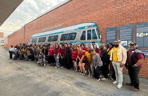 Lenoir-Rhyne and Southeast Louisiana choirs pose in front of a Freedom Rides bus mural