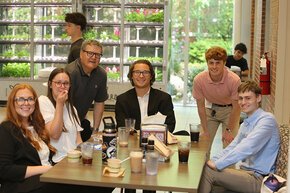 Students gathered with faculty members for a coffee at NCAS 2026