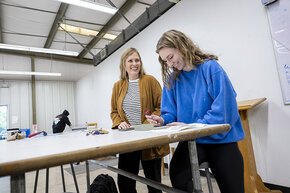 Claire Pope works with a student in the LR art studios
