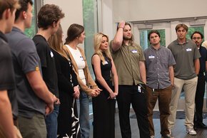 Students stand in a row to introduce themselves to the group