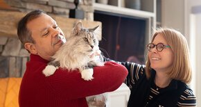 Glenn McGee holds Sam the Cat while Summer McGee pets Sam